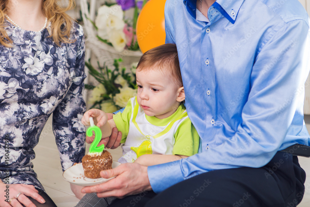 family, parenthood, happy birthday and holiday concept - close-up happy mother and father and child with cake. family, parenthood, happy birthday and holiday concept - close-up happy mother and father and child with cake.