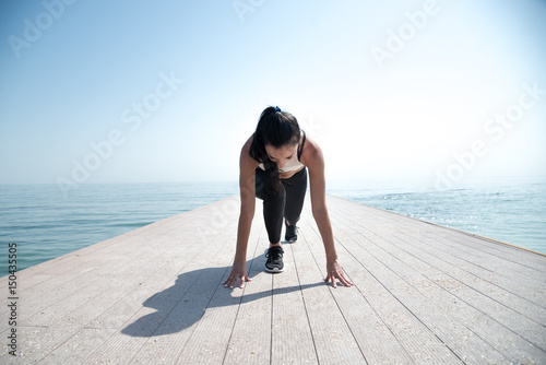 Young beautiful sportive girl preparing to run photo