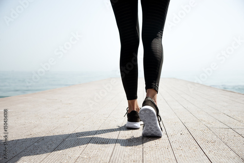 Young beautiful sportive girl preparing to run photo