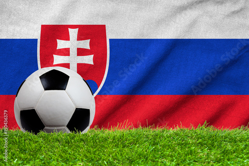 Football on grass field with wave flag of Slovakia
