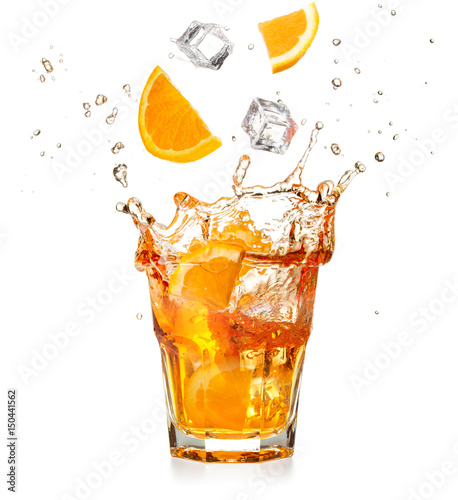 orange slices and ice cubes dropping into a splashing cocktail 