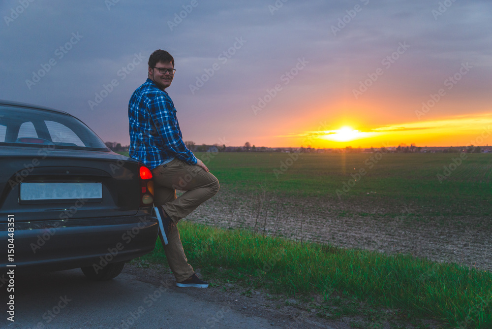 Fototapeta premium car trip man stops to look sunrice on the highway
