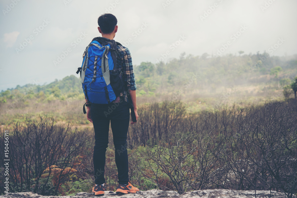 Obraz premium Hiker with backpacks standing on top of a mountain and enjoying nature view.
