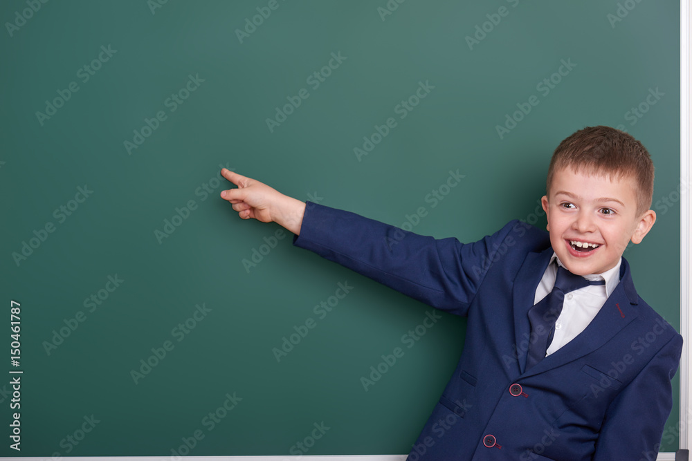 school boy point the finger near blank chalkboard background, dressed in classic black suit, group pupil, education concept school boy point the finger near blank chalkboard background, dressed in classic black suit, group pupil, education concept