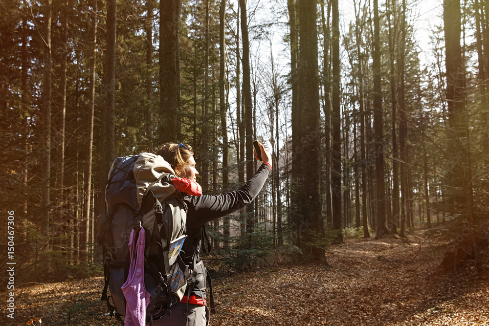 Fototapeta premium Woman taking a selfie on a hike through the woods