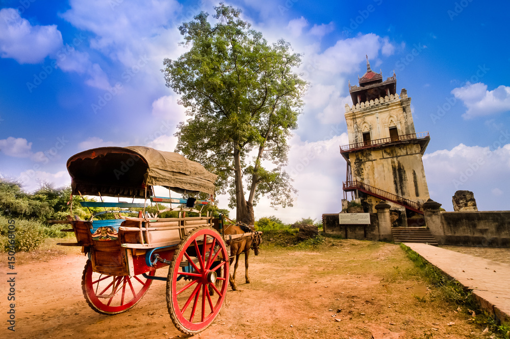 Horse Drawn Carriage parking in front of Nanmyin watchtower in Inwa ancient city, Mandalay Myanmar. Nanmyin watchtower is one of the most famous tourist destination in Mandalay.