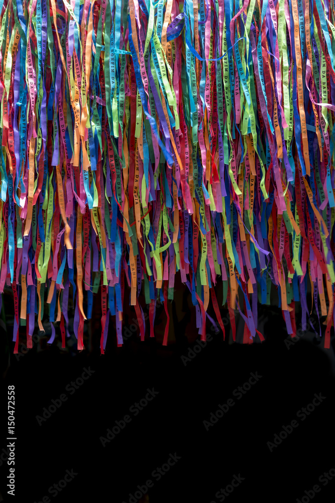 Abstract background of colorful Brazilian wish ribbons fading into black