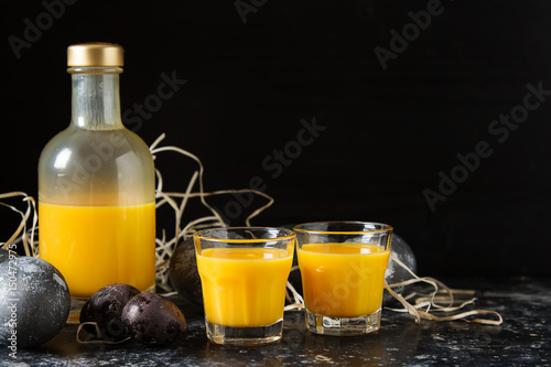 Traditional Italian yellow egg liquor, Bombardino. Dark background. Copy space.