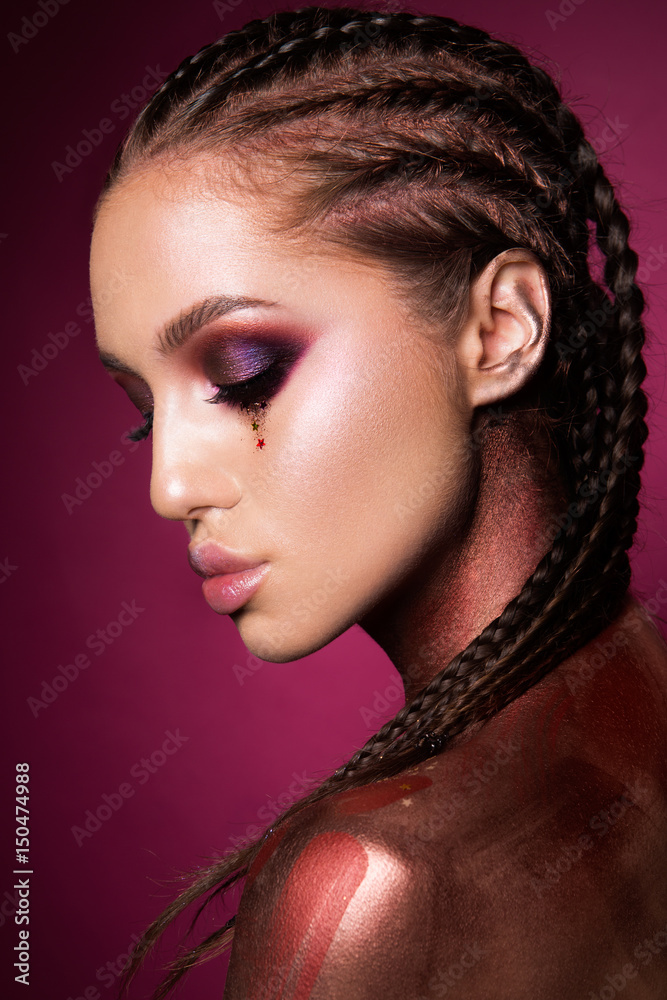 Portrait of beautiful woman with sparkles on her face. Girl with art make up in color light. Fashion model with colorful make-up Portrait of beautiful woman with sparkles on her face. Girl with art make up in color light. Fashion model with colorful make-up