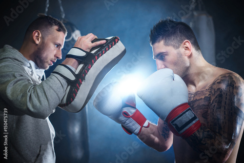 Male boxer sparring with personal trainer © gpointstudio