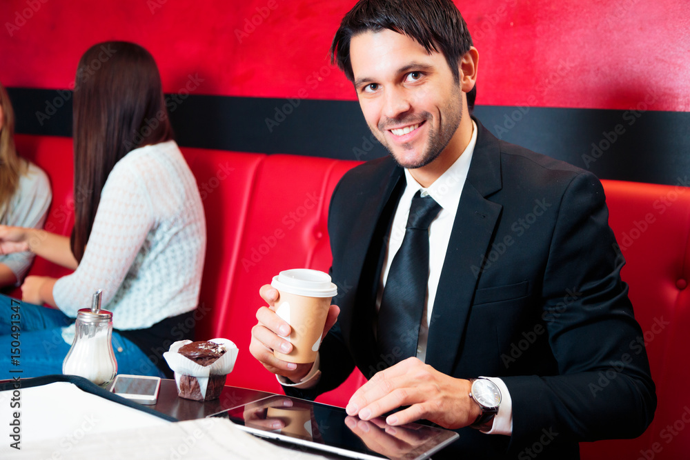 Businessman Sitting In A Cafe, Working On His Tablet