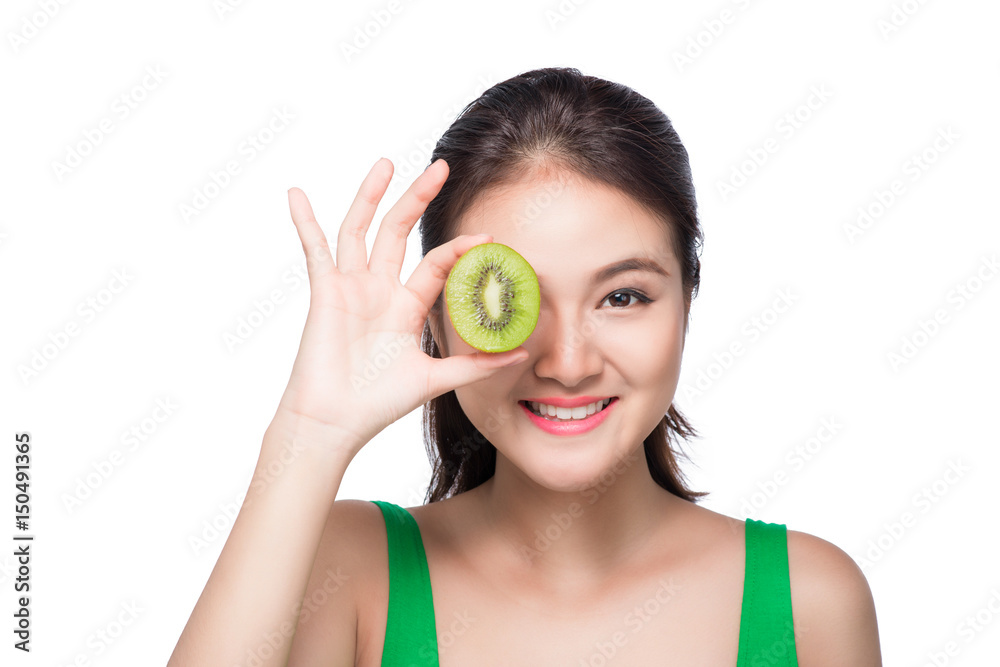 Tropical fruits. Healthy eating. Charming young asian woman holding fresh juicy kiwi and smiles. Green background. Tropical fruits. Healthy eating. Charming young asian woman holding fresh juicy kiwi and smiles. Green background.
