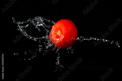 Tomato and water on a black background