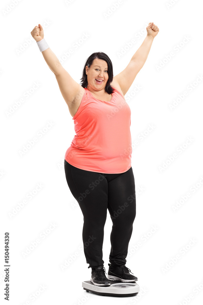 Overweight woman standing on a weight scale and gesturing happiness Overweight woman standing on a weight scale and gesturing happiness