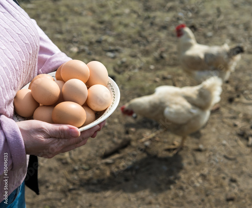 Woman farmer holding fresh organic eggs