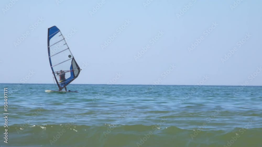 People learn windsurfing on the Baltic Sea in Zelenogradsk. In the background a dry cargo ship. People learn windsurfing on the Baltic Sea in Zelenogradsk. In the background a dry cargo ship.