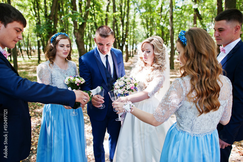 Wedding couple with bridesmaids on blue dresses and best mans having fun at wedding day.