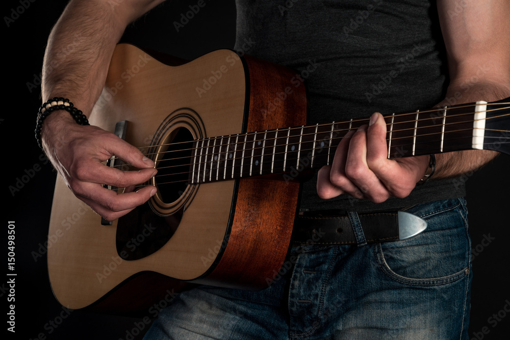 Fototapeta premium Playing guitar. Acoustic guitar in the hands of the guitarist. Horizontal frame