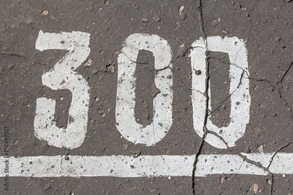 Number 300, three hundred, painted on asphalt, running track Number 300, three hundred, painted on asphalt, running track