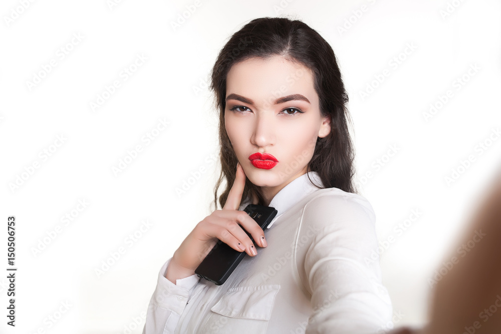 Beautiful girl with red lips doing selfie on white background Beautiful girl with red lips doing selfie on white background