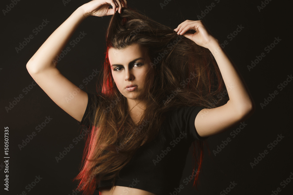 Stylish brunette woman with creative makeup posing at studio with red light Stylish brunette woman with creative makeup posing at studio with red light