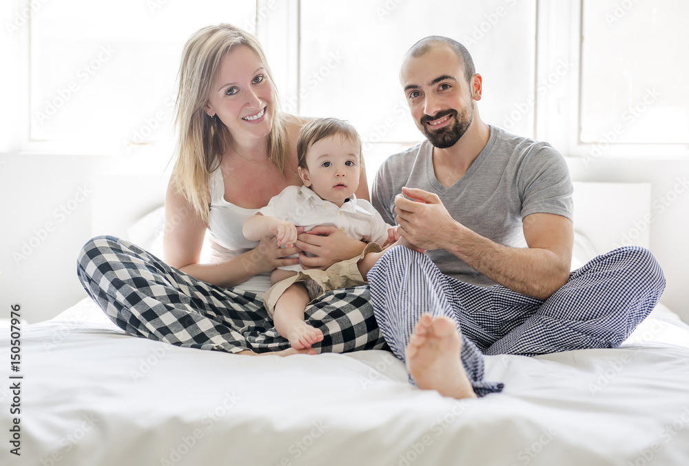 Faces of the Happy and fun family lying in bed Faces of the Happy and fun family lying in bed