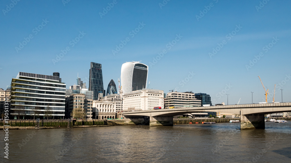 Business London. A view across the River Thames with London Bridge leading towards the financial skyscrapers of The City of London.