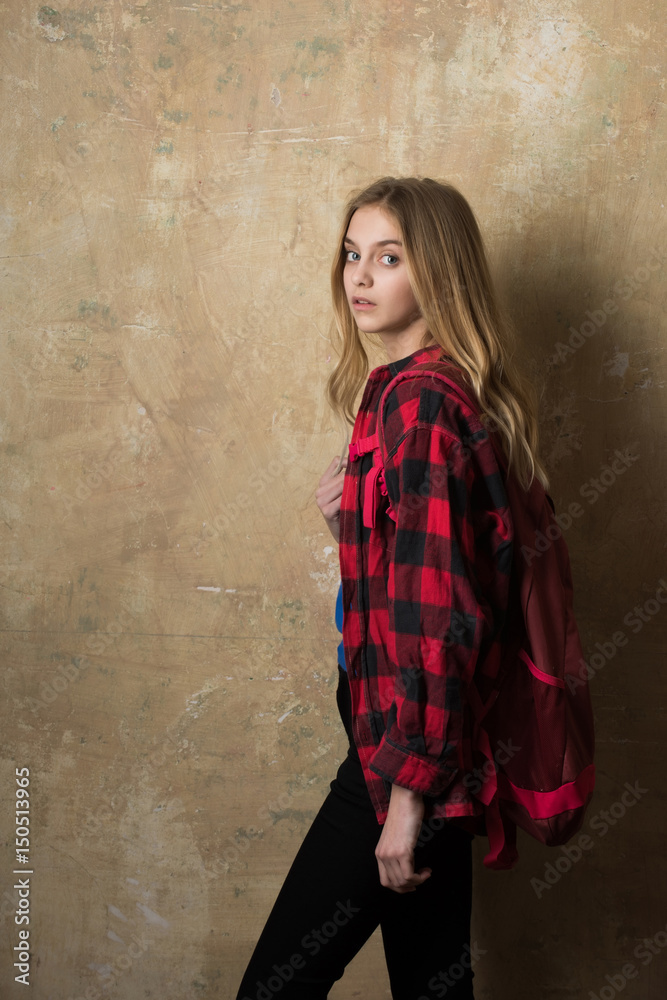 beautiful girl with backpack in stylish red checkered shirt
