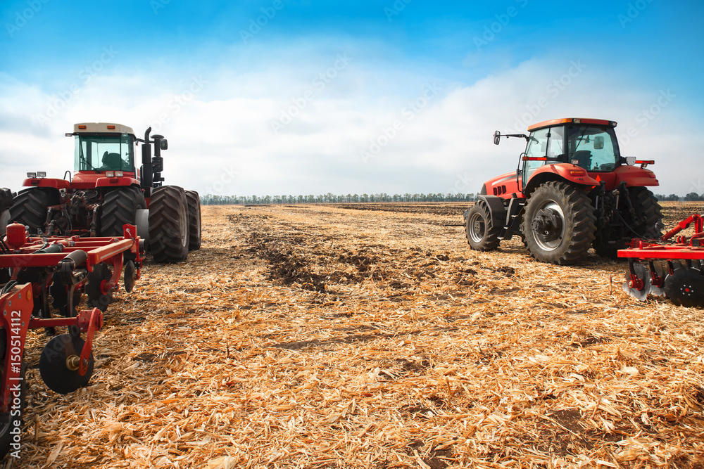 Obraz premium Two tractors in a field.
