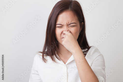 Young Asian woman  holding her nose because of a bad smell.