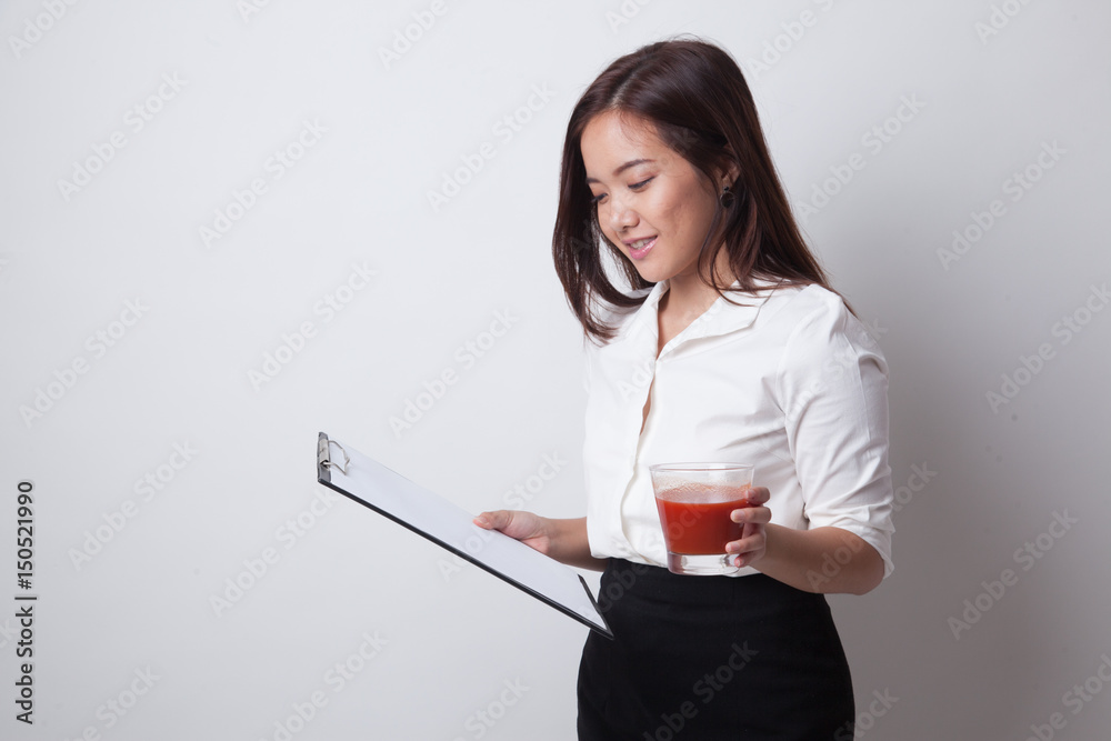 Asian business woman with clipboard and tomato juice. Asian business woman with clipboard and tomato juice.