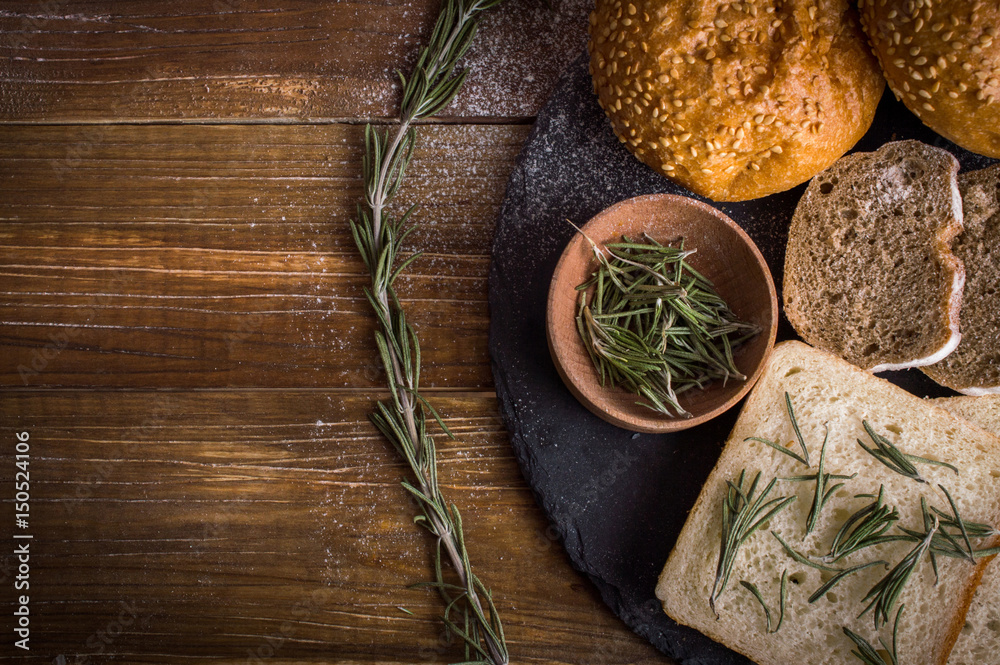 Bread and rosemary on a wooden background Bread and rosemary on a wooden background