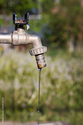 Brass water tap in nature background.