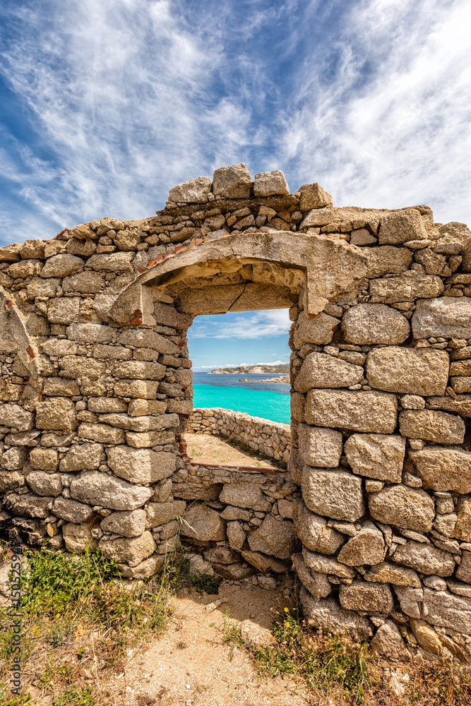 Turquoise sea viewed through window of derelict building in Corsica