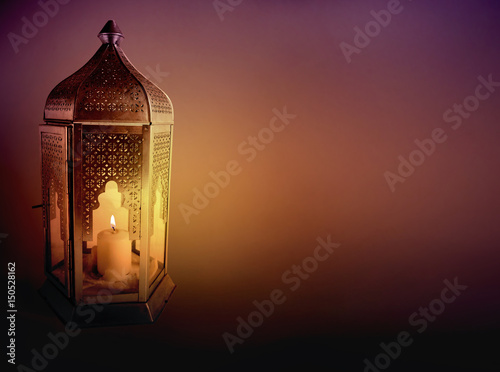 Quadro su tela Ornamental Arabic lantern with burning candle glowing at night