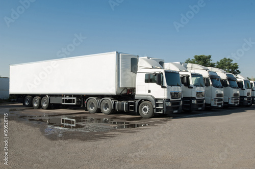 cargo vehicles stand in a row on a parking. freight transportation. truck park