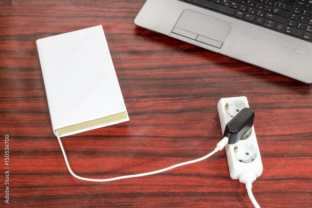 Book connected to a power outlet. Book connected to a power outlet.