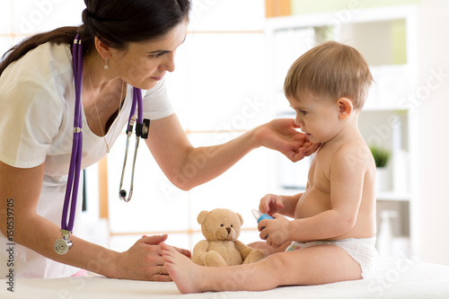 Doctor paediatrician checking boy's neck