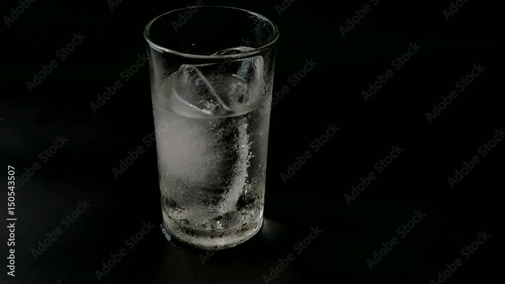 time laps Melting of ice in glass With a black background time laps Melting of ice in glass With a black background