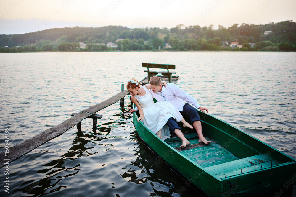Obraz premium Young couple in love on sail boat having fun with tablet - Happy luxury lifestyle on yacht sailboat