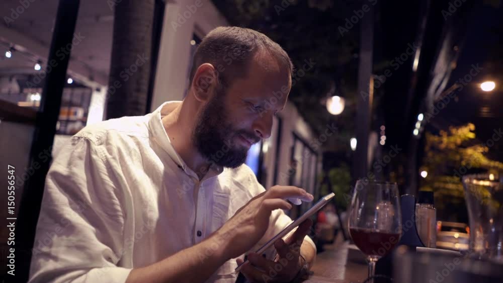 Young, handsome man using tablet computer in cafe during evening, 4K
Young, handsome man using tablet computer in cafe during evening, 4K