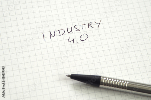 Industry 4.0 in handwriting on checkered paper with pen