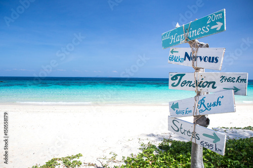 Concept of happiness wooden sign at the white sand beach photo