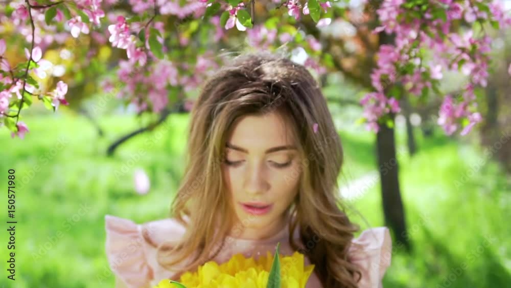 Handsome woman with bouquet of tulips at flowered garden. Handsome woman with bouquet of tulips at flowered garden.