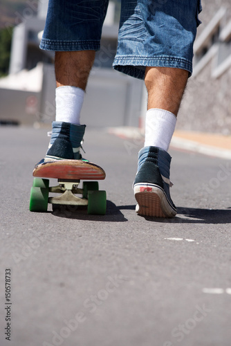 back of man skateboarding on street