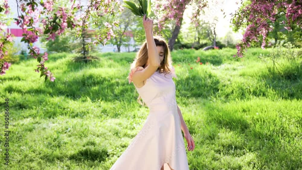 Handsome woman with bouquet of lilies of the valley is getting pleasure. Nature spring concept