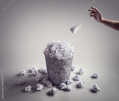 Throwing paper ball in the waste paper basket or office bin