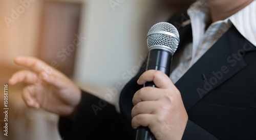 blurred of Businesswoman speech with microphone, hand gesturing protesting or belief concept for explaining