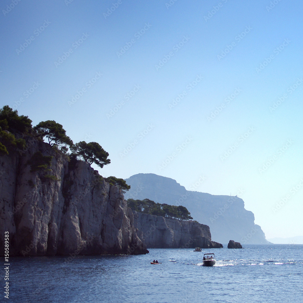 Mountain profile portrait, mountains, cliffs, coastline and blue sea, blue sky and boats