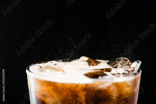 Ice cola with splashing CO bubbles in a glass photo